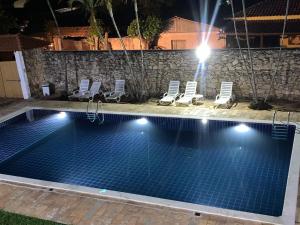 einen Pool in der Nacht mit Liegestühlen und einem Pool in der Unterkunft Pousada o Amanhecer in Tiradentes
