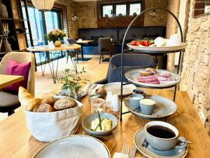 una mesa cubierta con platos de repostería y tazas de café en Boutique Hotel Waldwiese en Hohwacht