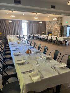 una mesa larga con mesas y sillas blancas en Hôtel Far Hills, en Val-Morin
