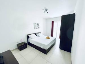 a white bedroom with a bed and a window at Modern St.Julian's Heart 2 Bed 2 Bath | Paceville in St. Julianʼs