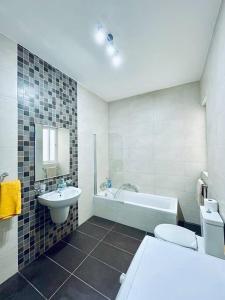 a bathroom with a sink and a tub and a toilet at Modern St.Julian's Heart 2 Bed 2 Bath | Paceville in St. Julianʼs