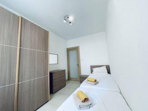 1 dormitorio con 2 camas y armario de madera en Stylish Modern Central Apartment 4 Paceville, en San Julián