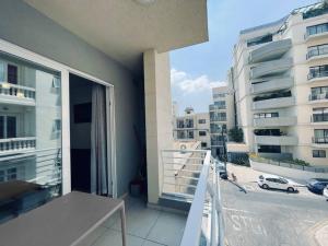 a balcony of a building with a view of a street at Modern St.Julian's Heart 2 Bed 2 Bath | Paceville in St. Julianʼs