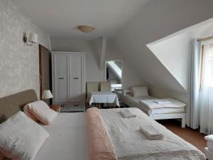 インドルジフーフ・フラデツにあるPenzion U Šelongůの白い部屋で、ベッド2台、窓が備わります。