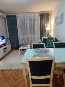 sala de estar con mesa y sofá en Faraon Apartman en Kragujevac