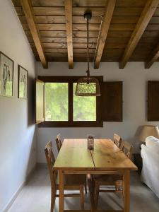 uma sala de jantar com uma mesa de madeira e cadeiras em Casa rural en jerte: La casa del molino em Jerte