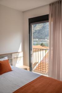 ein Schlafzimmer mit einem Bett und einem großen Fenster in der Unterkunft Marea DeLuxe Apartments in Kotor