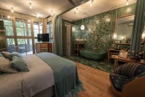 a bedroom with a large bed and a bath tub at Balquisse Heritage Hotel in Jimbaran