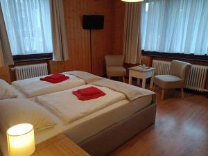 a bedroom with two beds with red towels on them at Dein Hotel Suite Wellness in Hahnenklee-Bockswiese