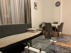 ein Wohnzimmer mit einem Sofa und einem Tisch in der Unterkunft Stan na dan Centar Banja Luka in Banja Luka
