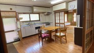 a kitchen with a table and chairs in a room at 旅する人生ハウス鹿屋 in Kanoya