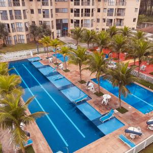 an aerial view of a resort pool with palm trees at Apartamento Reserva do Sahy - Condomínio Aldeia dos Reis in Mangaratiba
