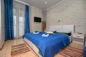 - une chambre avec un lit doté de draps bleus et de rideaux bleus dans l'établissement Apartment Camelia, à Poreč