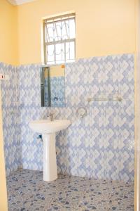 bagno con lavandino e specchio di Pearl suites a Bungoma