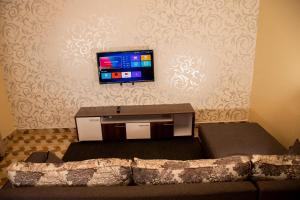 sala de estar con sofá y TV de pantalla plana en Pearl suites, en Bungoma