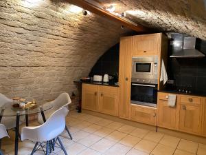 uma cozinha com armários de madeira e uma mesa com cadeiras em Cobble Cottage em Lindley