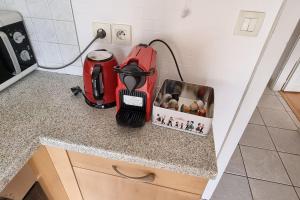 blat kuchenny z czerwonym urządzeniem na blacie w obiekcie Cosy Rent Strasbourg Garage Wifi Terrasse Dream Host Romain w Strasburgu
