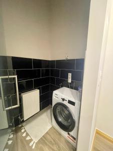 a washing machine in a bathroom with black tiles at Comfort Lux Design Apartment #Castle #2bedroom #freeparking in Budapest