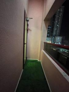 a narrow hallway with a green floor in a building at Beach view, Cozy 2BR apartment in Sharjah
