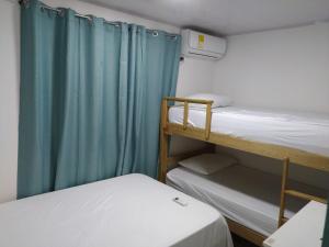a room with two bunk beds and a blue curtain at Apartamentos AJ place 2 in San Andrés