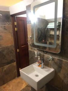 a bathroom with a white sink and a mirror at EL GRAN TORIL in Taxco de Alarcón