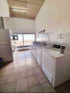 eine große Küche mit weißen Geräten und einem großen Fenster in der Unterkunft Espacio Walden I Practical Comfort & location in Buenos Aires