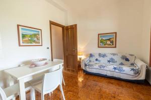 Una sala de estar con una mesa y una cama. en 3-Casa sul mare con piscina vicino Cefalù, en Campofelice di Roccella
