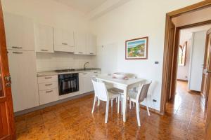 Una cocina blanca con una mesa y sillas blancas. en 3-Casa sul mare con piscina vicino Cefalù, en Campofelice di Roccella 18 fotos más