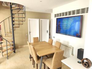 une salle à manger avec une table et des chaises en bois dans l'établissement Sitges Balcony Pool & Seaside Apartment, à Sitges