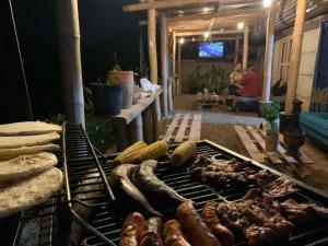 un grill contenant différents types de viande dans l'établissement Glamping la veranera, à San Vicente