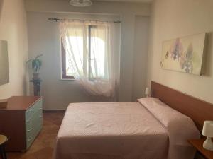 1 dormitorio con cama y ventana en Villa Stefania, en Marina di Camerota
