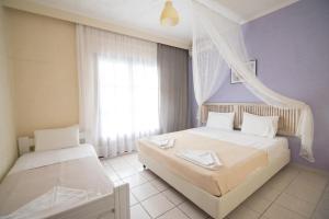 a bedroom with two beds and a window at Villa Flegos in Skala Fourkas