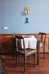 a dining room table with two chairs and a blue wall at Schloss Schmarsow, Wohnung BLAU 