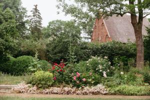 a garden of flowers with a church in the background at Schloss Schmarsow, Wohnung BLAU 