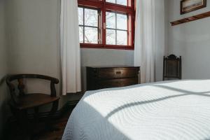 a bedroom with a bed and a chair and a window at Schloss Schmarsow, Wohnung BLAU 