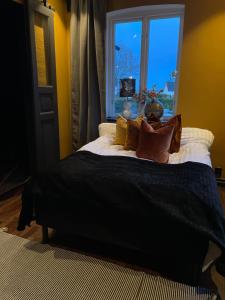 a bed with a black blanket and a window at Lägenhet Söder om Landsvägen A in Skivarp