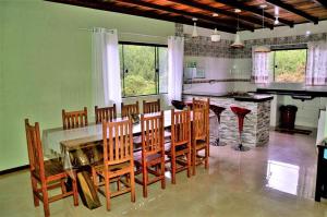 uma cozinha com uma mesa de jantar e cadeiras em Chácara Vale Verde em Camanducaia