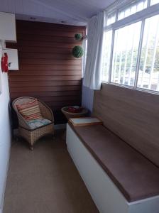 a small room with a bench and a window at APTO COM VARANDA - 5KM DO AEROPORTO BSB - Nucleo Bandeirante in Brasilia
