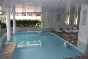 a large blue swimming pool in a building at Ubatuba - Frente Mar Praia Grande in Ubatuba