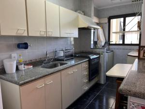 a kitchen with a sink and a stove at Ubatuba - Frente Mar Praia Grande in Ubatuba