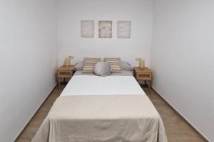 een bed in een kamer met twee tafels bij Rinconcito en el almendral in Jaén