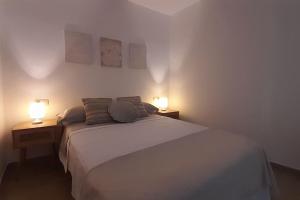 a bedroom with a bed and two lamps on two tables at Rinconcito en el almendral in Jaén