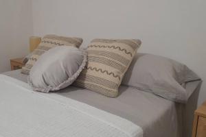 a bed with four pillows on top of it at Rinconcito en el almendral in Jaén
