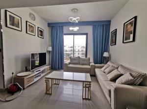 uma sala de estar com um sofá e uma mesa em 1BR Warm and comfortable APT em Sharjah