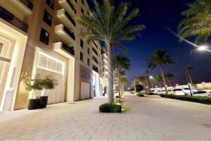 a palm tree in front of a building at night at 1BR Warm and comfortable APT in Sharjah