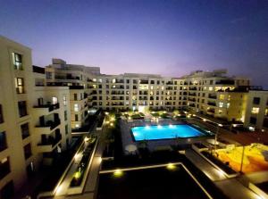 a large building with a swimming pool at night at 1BR Warm and comfortable APT in Sharjah