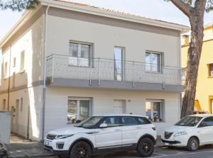 deux voitures garées devant une maison blanche dans l'établissement Affittacamere Ceccarini, à Riccione