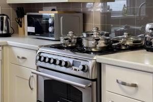 a kitchen with a stove with pots and pans on it at Wester-Moor comfy modern house in Barnstaple by StayStay com in Barnstaple