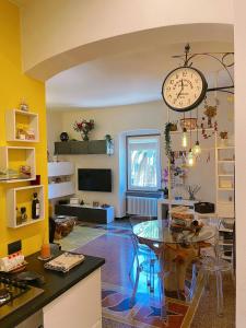 ein Wohnzimmer mit einem Tisch und einer Uhr an der Wand in der Unterkunft Casa di Olli in Sestri Levante