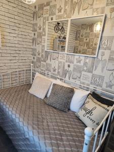 een kamer met een bed met kussens en een bakstenen muur bij Rehoboth in Yew Gardens in Doncaster